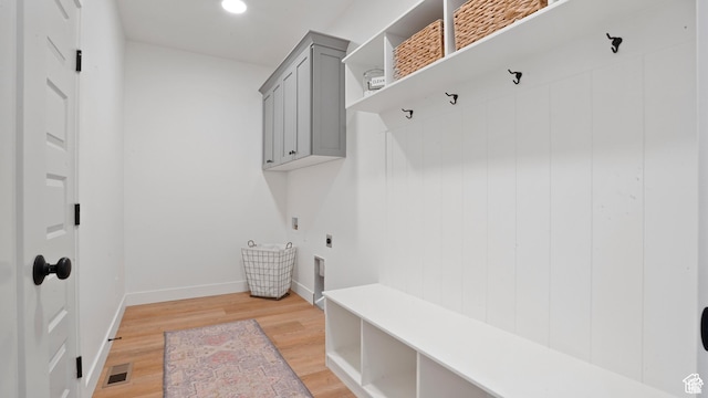 mudroom with baseboards, visible vents, and light wood-style floors