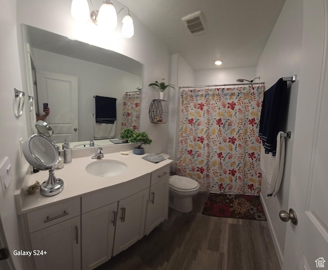 full bathroom with wood finished floors, vanity, curtained shower, toilet, and visible vents