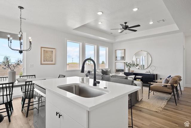 330 W Rosie Loop Unit 45E, Cedar City, UT 84720 - kitchen with a sink, a tray ceiling, light wood-style floors, a center island with sink, and a chandelier