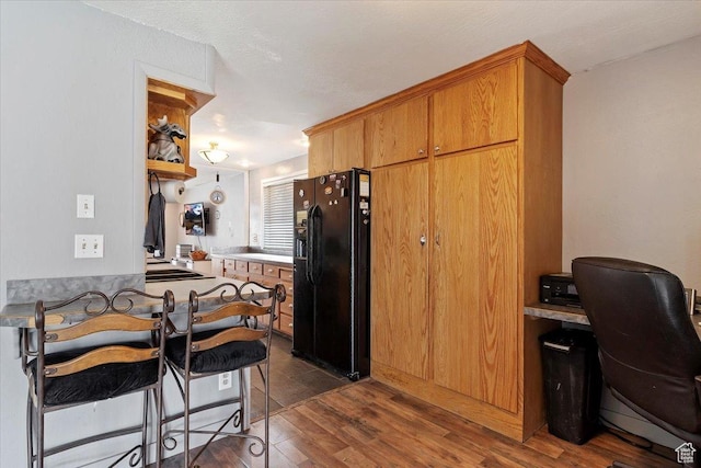 613 N 100 E, Brigham City, UT 84302 - kitchen featuring dark wood-style flooring, brown cabinetry, a peninsula, and black refrigerator with ice dispenser
