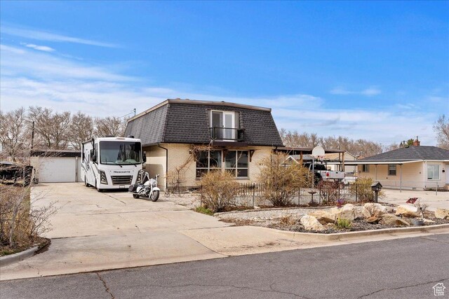 613 N 100 E, Brigham City, UT 84302 - view of front of property with fence, driveway, mansard roof, brick siding, and a garage