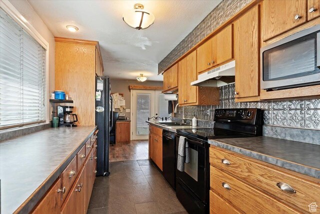 613 N 100 E, Brigham City, UT 84302 - kitchen with tasteful backsplash, under cabinet range hood, a sink, black appliances, and brown cabinetry