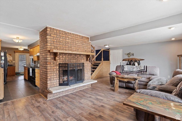 613 N 100 E, Brigham City, UT 84302 - living area featuring a fireplace, dark wood-style flooring, and stairs