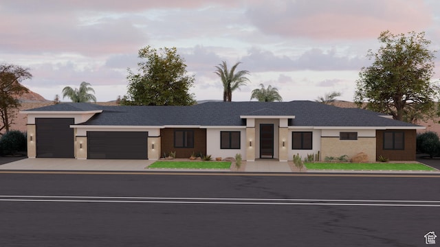 view of front facade with driveway, stucco siding, and an attached garage