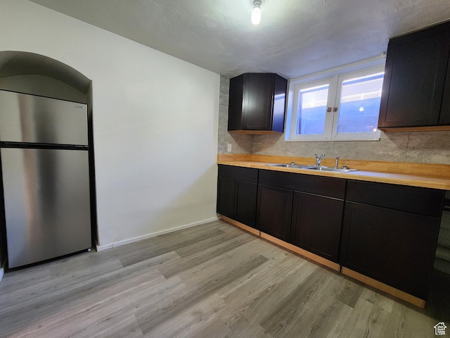 383 S 100 W, Price, UT 84501 - kitchen featuring freestanding refrigerator, a sink, light wood-style floors, decorative backsplash, and dark cabinets
