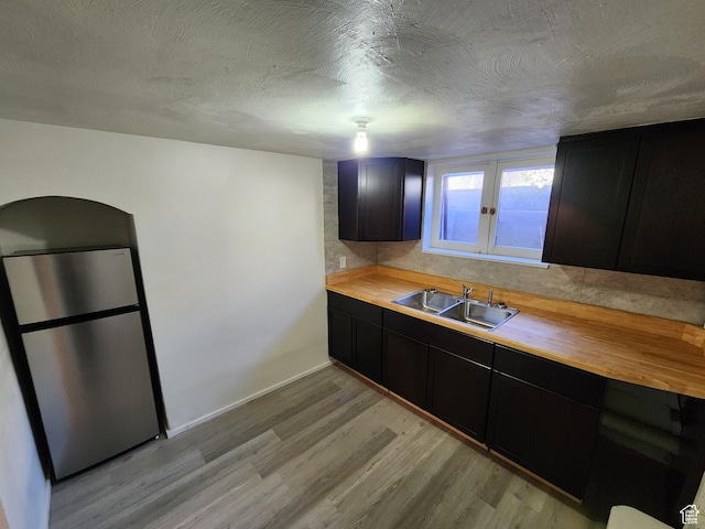 383 S 100 W, Price, UT 84501 - kitchen featuring freestanding refrigerator, butcher block counters, dark cabinetry, light wood-style flooring, and a textured ceiling