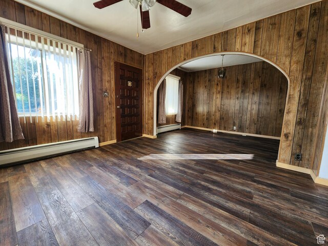 383 S 100 W, Price, UT 84501 - unfurnished room with a baseboard heating unit, arched walkways, wood walls, a ceiling fan, and wood finished floors