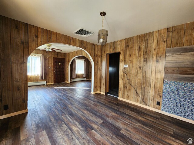 383 S 100 W, Price, UT 84501 - unfurnished room with arched walkways, a baseboard radiator, wooden walls, dark wood-style flooring, and baseboards