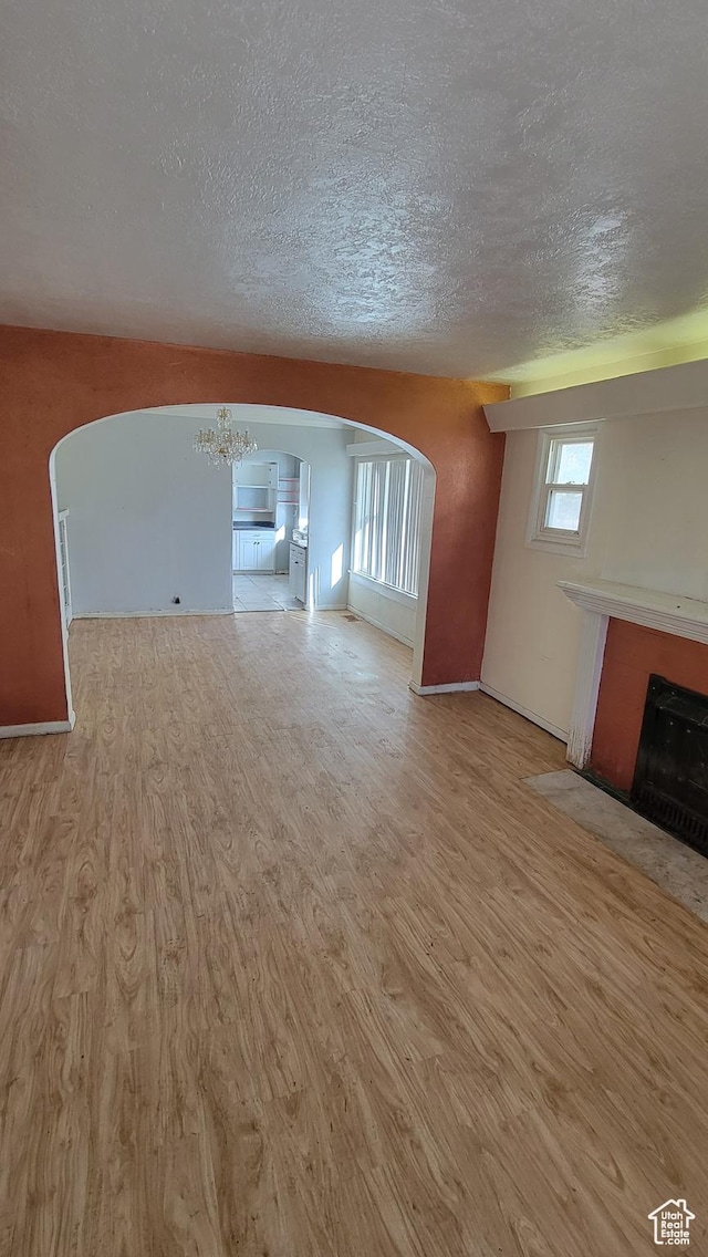 390 S 400 W, Logan, UT 84321 - unfurnished living room with a fireplace with flush hearth, wood finished floors, and arched walkways