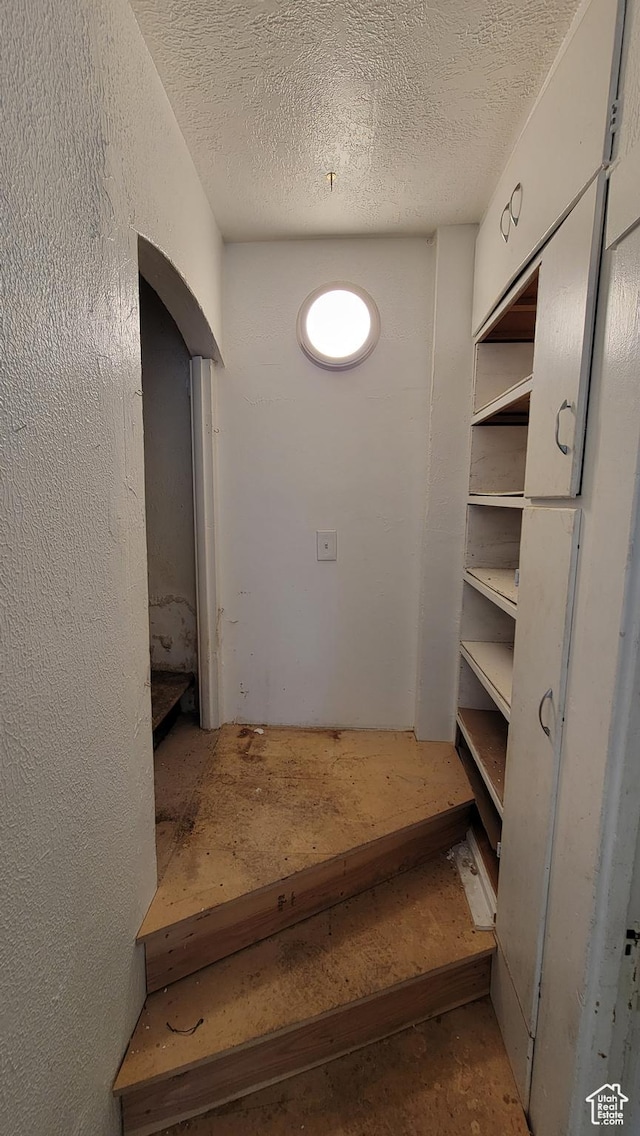 390 S 400 W, Logan, UT 84321 - stairway featuring arched walkways, a textured wall, and a textured ceiling