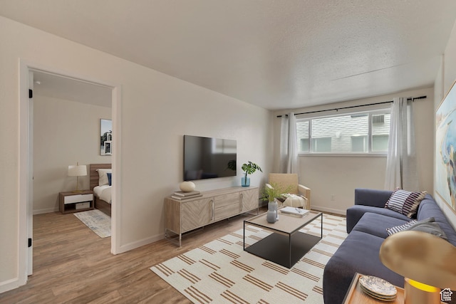 742 S 400 E Unit H102, Salt Lake City, UT 84111 - living area featuring a textured ceiling, baseboards, and wood finished floors