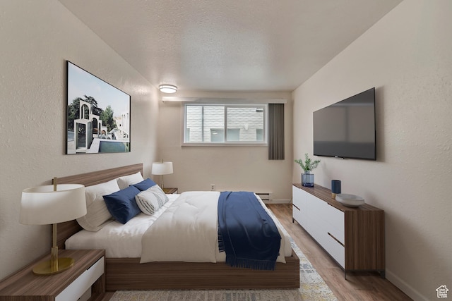 742 S 400 E Unit H102, Salt Lake City, UT 84111 - bedroom with a textured ceiling, baseboards, light wood-style floors, a baseboard heating unit, and a textured wall