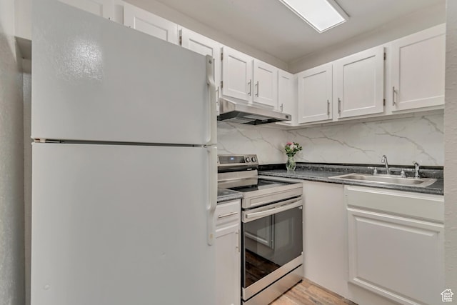 742 S 400 E Unit H102, Salt Lake City, UT 84111 - kitchen with under cabinet range hood, stainless steel electric stove, a sink, dark countertops, and freestanding refrigerator