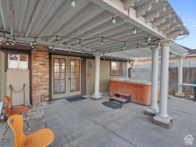 view of patio with fence, french doors, and a hot tub