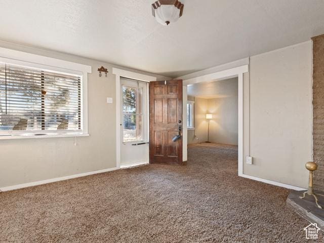 carpeted spare room featuring baseboards