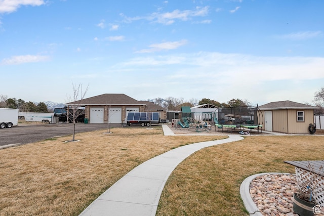 12381 S 3600 W, Riverton, UT 84065 - view of yard featuring a trampoline, playground community, an outbuilding, fence, and aphalt driveway