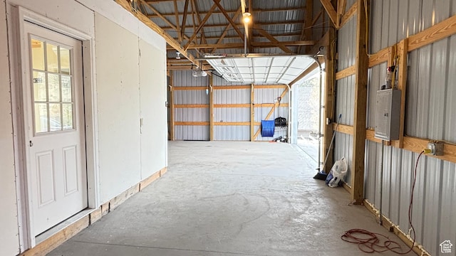 miscellaneous room featuring concrete flooring, electric panel, and a garage