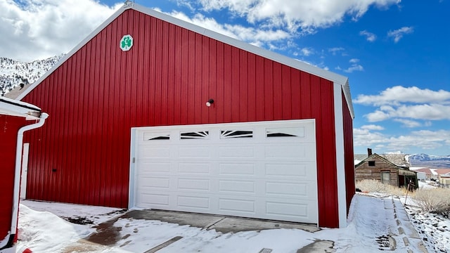 snow covered garage featuring a garage