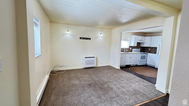 interior space featuring heating unit, baseboard heating, baseboards, and a sink