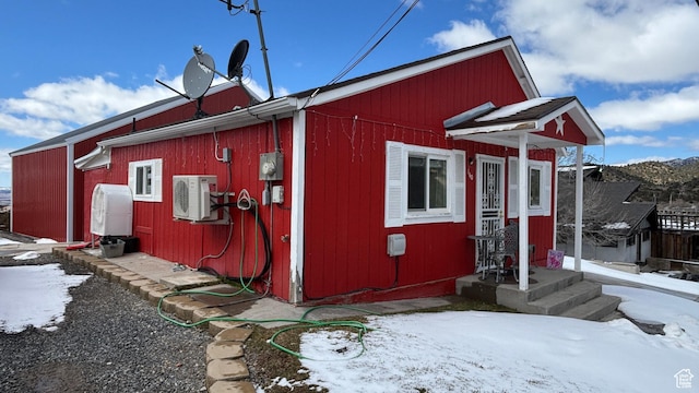 snow covered structure featuring ac unit