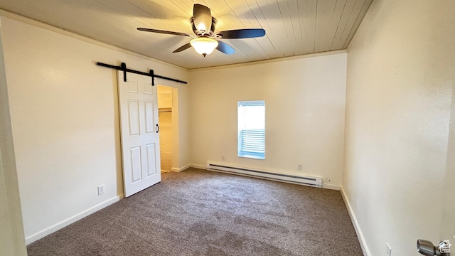 unfurnished room with baseboard heating, a barn door, ceiling fan, baseboards, and carpet flooring