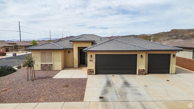 633 N 2850 W, Hurricane, UT 84737 - prairie-style house with stone siding, driveway, an attached garage, a tile roof, and stucco siding
