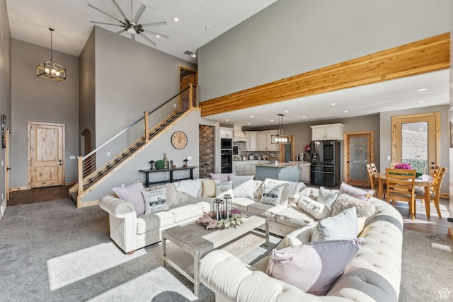 1101 E Stage Coach Run N, Morgan, UT 84050 - living room featuring light colored carpet, stairway, a high ceiling, ceiling fan with notable chandelier, and recessed lighting