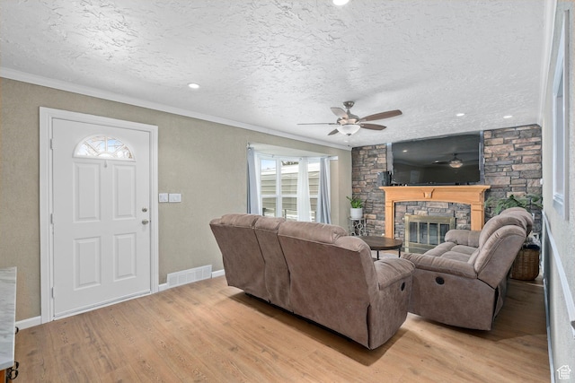 319 N 800 W, Orem, UT 84057 - living room featuring visible vents, light wood finished floors, ornamental molding, a ceiling fan, and a stone fireplace