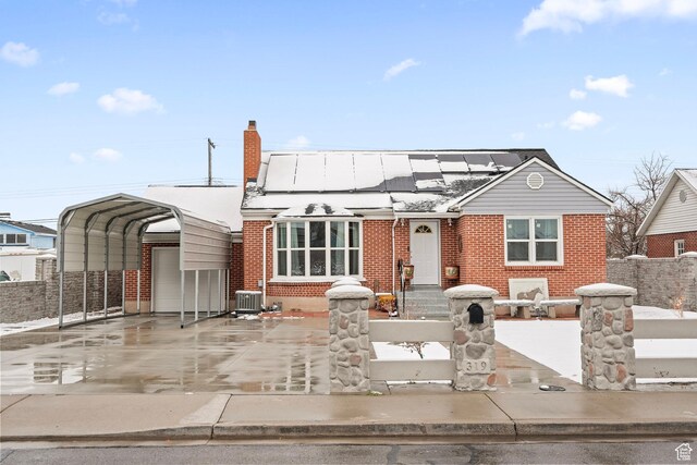 view of front of house featuring a fenced front yard, a carport, and brick siding