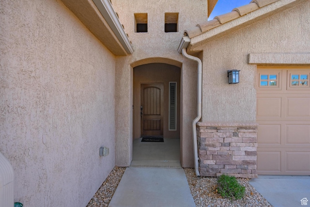 1369 W Country Club Dr, St George, UT 84790 - view of exterior entry with stucco siding, an attached garage, and stone siding