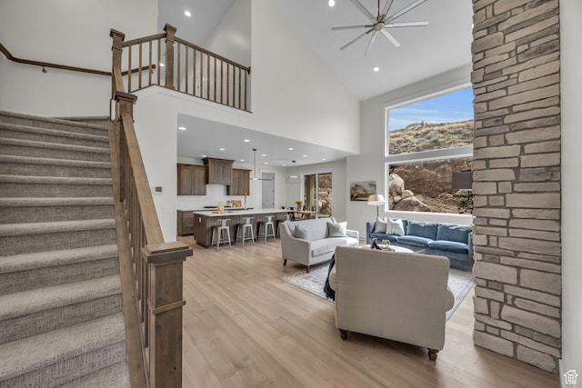 6579 W Bonnie Jean Ln Unit 12, Herriman, UT 84096 - living room with stairway, a ceiling fan, light wood-style floors, a towering ceiling, and recessed lighting