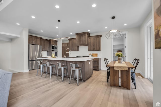 6579 W Bonnie Jean Ln Unit 12, Herriman, UT 84096 - kitchen featuring light countertops, recessed lighting, appliances with stainless steel finishes, light wood-style floors, and a large island with sink
