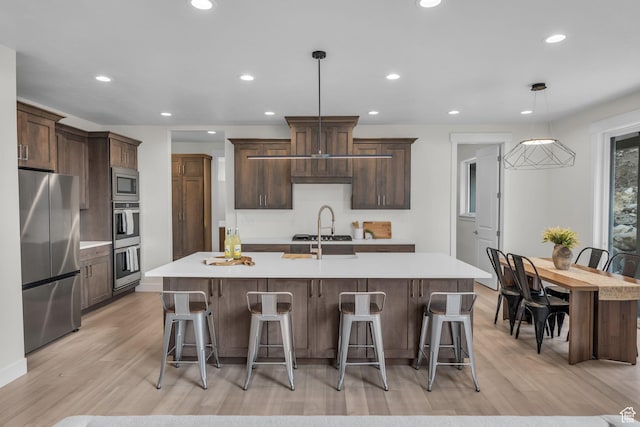 6579 W Bonnie Jean Ln Unit 12, Herriman, UT 84096 - kitchen featuring a large island with sink, a kitchen bar, stainless steel appliances, decorative light fixtures, and recessed lighting