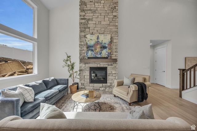 6579 W Bonnie Jean Ln Unit 12, Herriman, UT 84096 - living area featuring a stone fireplace, baseboards, high vaulted ceiling, and wood finished floors