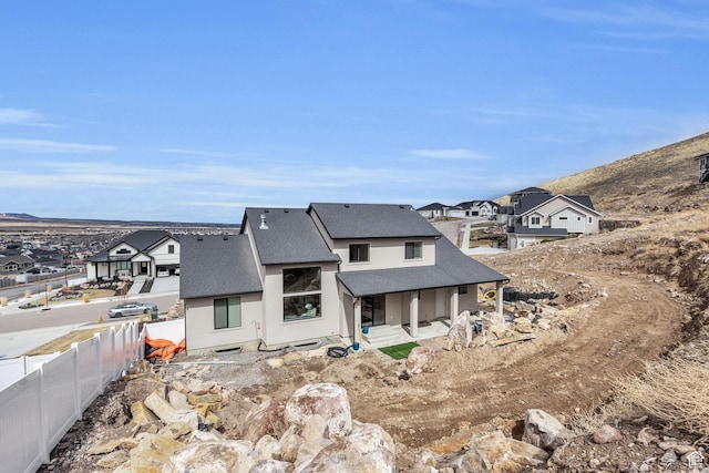6579 W Bonnie Jean Ln Unit 12, Herriman, UT 84096 - back of house featuring a residential view, roof with shingles, stucco siding, and fence
