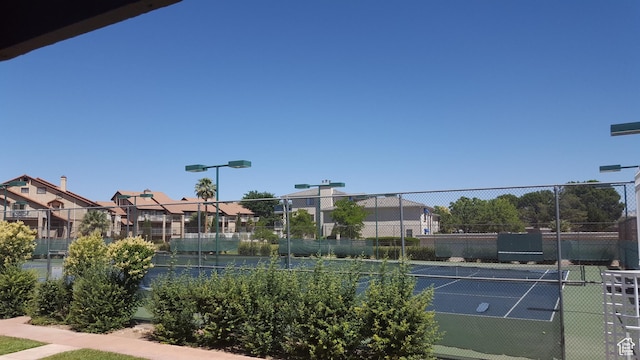 view of sport court with fence and a residential view