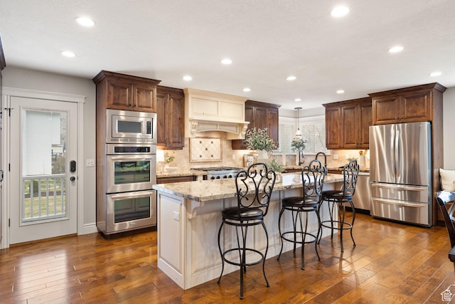 4721 W Country Club Dr, Highland, UT 84003 - kitchen featuring decorative backsplash, a kitchen island, appliances with stainless steel finishes, light stone counters, and dark wood-style floors