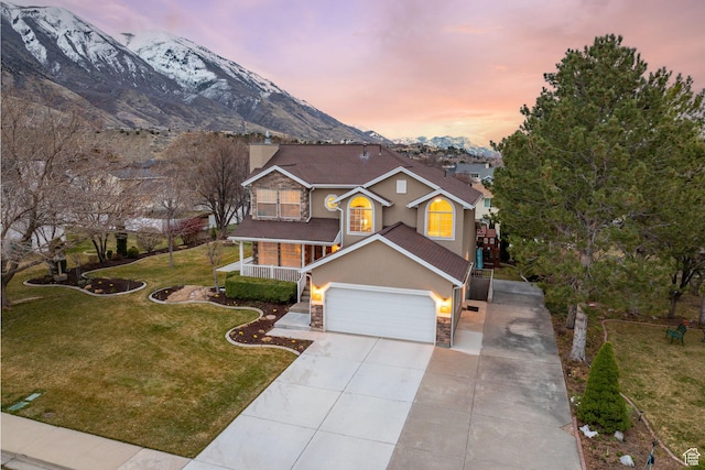 4721 W Country Club Dr, Highland, UT 84003 - view of front facade with a front yard, concrete driveway, a chimney, stucco siding, and a mountain view