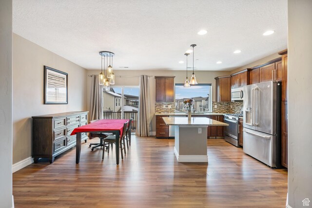 60 N 1100 W, Farmington, UT 84025 - kitchen with dark wood-style flooring, stainless steel appliances, a center island, backsplash, and hanging light fixtures
