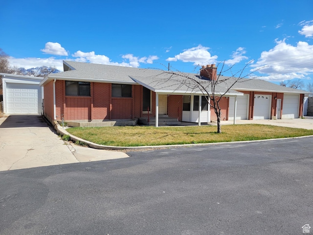 single story home featuring brick siding, a front yard, a garage, and entry steps
