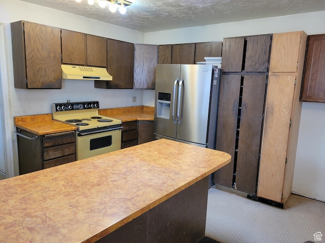 kitchen with stainless steel fridge, a textured ceiling, light countertops, under cabinet range hood, and white electric range
