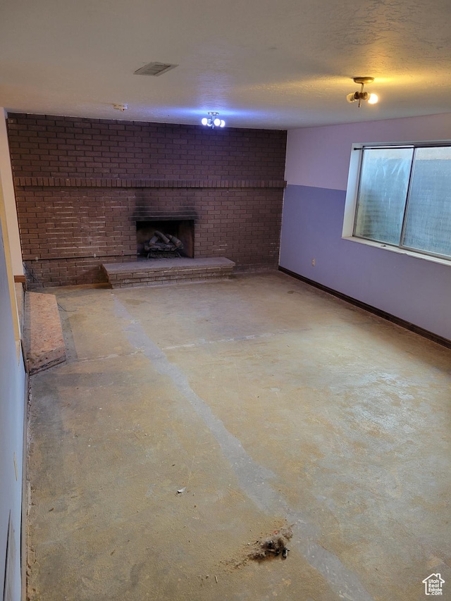below grade area featuring baseboards, a textured ceiling, and a fireplace