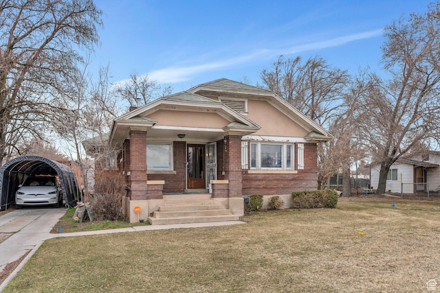 bungalow-style house with brick siding, a front yard, and stucco siding