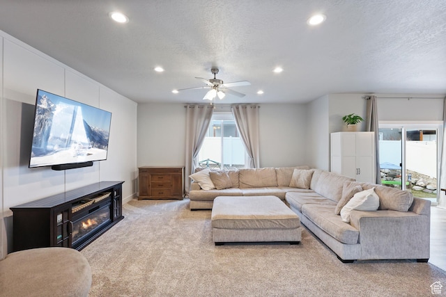 carpeted living room with a ceiling fan, a textured ceiling, and recessed lighting