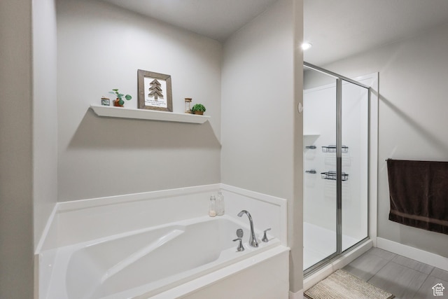 bathroom with a stall shower and a garden tub