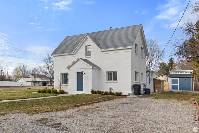 214 W 600 S, Heber City, UT 84032 - view of front of property with brick siding, a shingled roof, a front lawn, and an outdoor structure