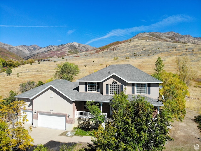 4216 N Wolf Creek Dr, Eden, UT 84310 - traditional home featuring concrete driveway, stucco siding, an attached garage, a porch, and a mountain view