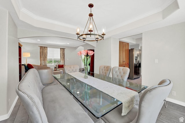 4216 N Wolf Creek Dr, Eden, UT 84310 - dining area with crown molding, an inviting chandelier, baseboards, a raised ceiling, and arched walkways