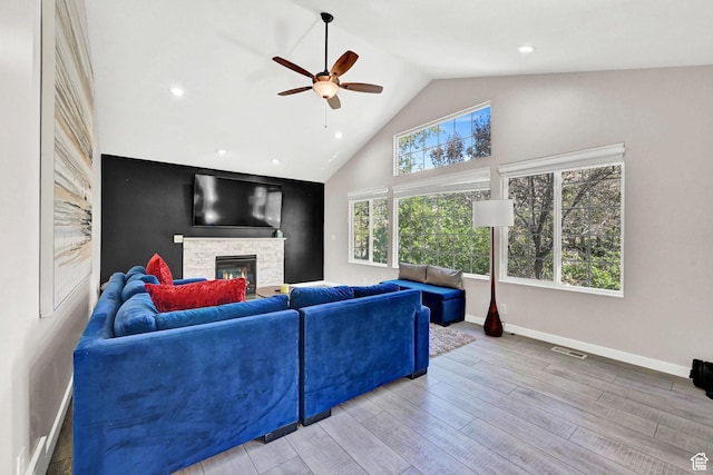 4216 N Wolf Creek Dr, Eden, UT 84310 - living room featuring baseboards, visible vents, a stone fireplace, ceiling fan, and wood finished floors