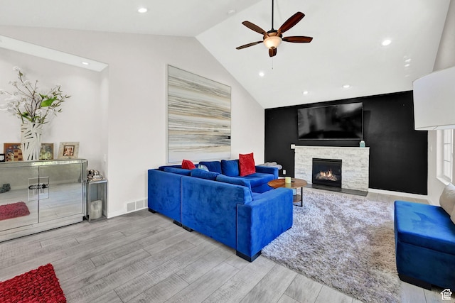 4216 N Wolf Creek Dr, Eden, UT 84310 - living room with a ceiling fan, wood finished floors, a stone fireplace, lofted ceiling, and visible vents